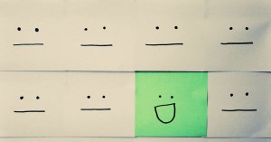 Image of Post-it Note Faces with one green face smiling