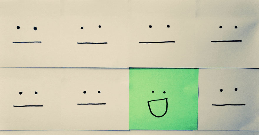 Image of Post-it Note Faces with one green face smiling