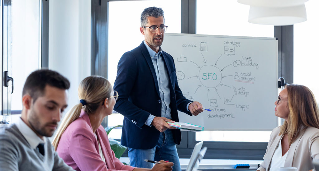 group of people sitting around a conference room table talking about SEO