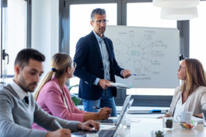 group of people sitting around a conference room table talking about SEO