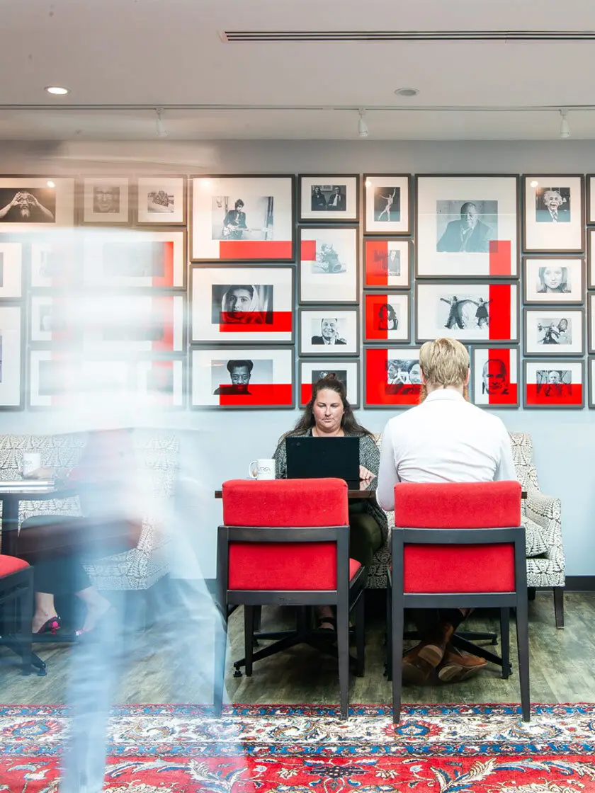 a couple of people sitting at a table with a laptop