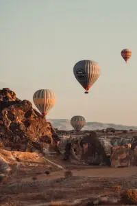 hot air balloons flying over a rocky landscape