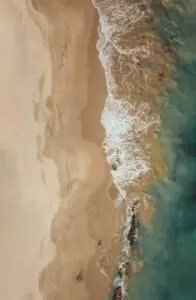 a beach with waves crashing on the shore