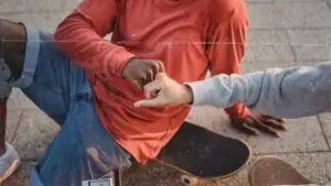 a person sitting on the ground holding up their fingers